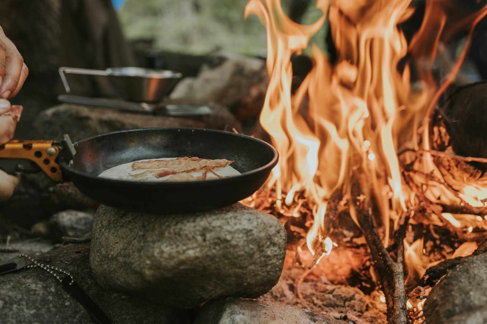 Cooking food over a skillet on a campfire